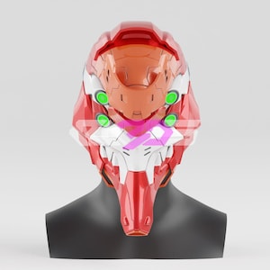 Puede incluir: Un casco rojo y naranja con detalles blancos y círculos verdes. El casco se muestra sobre una cabeza de maniquí negra. El diseño presenta una barbilla puntiaguda y una estructura angular compleja, lo que sugiere un tema futurista o de ciencia ficción.