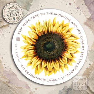 May include: A round sticker featuring a detailed watercolor sunflower with bright yellow petals and a dark center. The text surrounding the flower reads: Keep your face to the sunshine and you cannot see the shadow. It's what sunflowers do. ~Helen Keller.