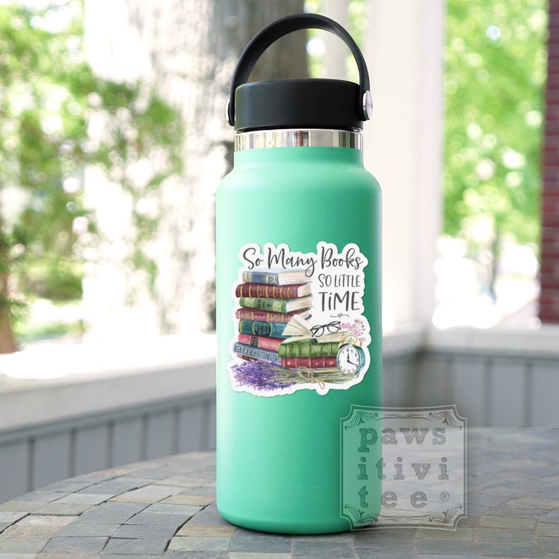 May include: A mint green water bottle with a black lid and handle, featuring a sticker of a stack of colorful books, a pair of glasses, an alarm clock, and lavender flowers with the text "So Many Books SO LITTLE TIME" printed in black.