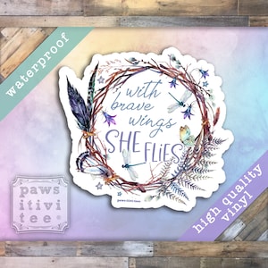May include: A watercolor sticker with a wreath of branches, feathers, and flowers. The text inside the wreath reads "with brave wings she flies".