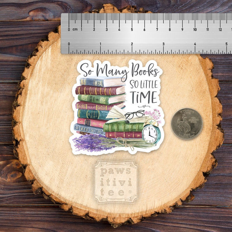 May include: A sticker featuring a stack of colorful books with the text So Many Books SO LITTLE TIME, a pair of glasses, a small alarm clock, and a sprig of lavender. A ruler shows the sticker is approximately 3.5 inches wide by 3.5 inches tall.