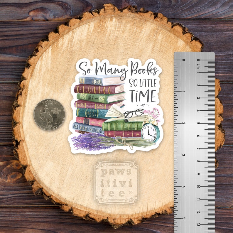 May include: A sticker featuring a stack of colorful books, an open book with glasses, a clock, and lavender, with the text So Many Books SO LITTLE TIME. A US quarter and a ruler showing approximately 2.5 inches in height are visible for scale.
