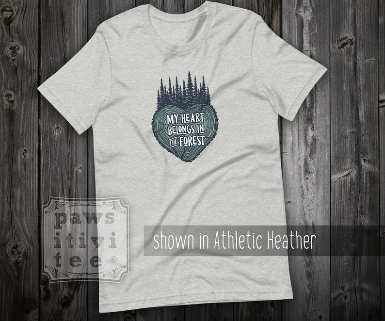 May include: A heather grey t-shirt with a forest green graphic of a tree stump heart with the text "My heart belongs in the forest".