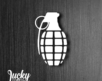 May include: White silhouette of a hand grenade on a dark wood background.