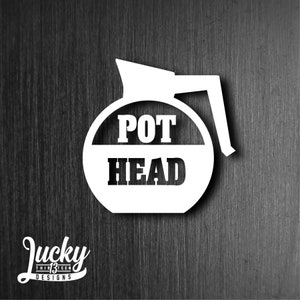 May include: White silhouette of a coffee pot with the words "POT HEAD" in black text.