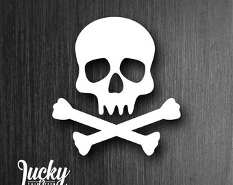 May include: A white skull and crossbones design on a dark wood background. The skull has a simple design with two eye sockets, a nose, and a mouth.
