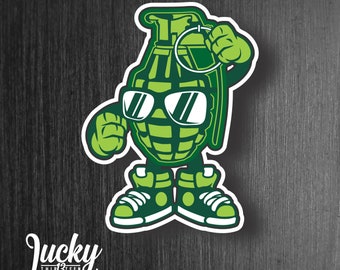 May include: A green cartoon grenade wearing sunglasses and sneakers. The grenade is holding a ring in its right hand. The image has the text "Lucky Thirteen Designs" at the bottom.