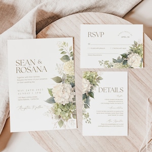 May include: Wedding invitation suite with white and green floral designs. The invitation card features the names "Sean & Rosana" in gold lettering. The RSVP card includes a section for dietary requirements. The details card provides information about the reception and accommodations.