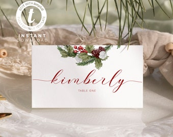 May include: White place card with a green holly sprig, red berries, and white cotton balls. The name "kimberly" is written in red cursive script with the text "Table One" below.