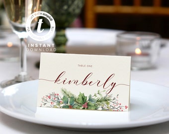 May include: A cream-colored place card with the name "Kimberly" in burgundy script. The card features a watercolor design of holly, berries, and evergreen branches. Text at the top reads "Table One". The words "Instant Download" are also visible.