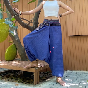 May include: A pair of blue, wide-legged pants with a drawstring waist and a decorative belt. The pants have a loose, flowing fit and are made of a soft, comfortable fabric.