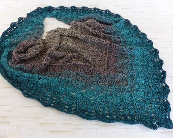 May include: A teal and brown crocheted shawl with a lacy pattern. The shawl is folded in half and has a gradient of color from brown to teal.