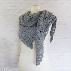 May include: A gray crocheted shawl with a lacy design. The shawl is draped over a white mannequin.