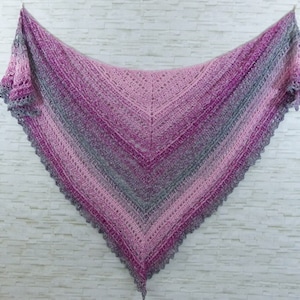 May include: A crocheted shawl in shades of pink and grey with a delicate lace border.