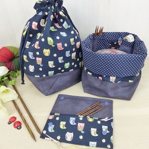 Könnte beinhalten: Drei blaue Stofftaschen mit Eulenmustern. Die größte Tasche ist eine Kordeltasche. Die mittlere Tasche ist ein zylindrischer Behälter mit einem weißen Tupfenmuster. Die kleinste Tasche ist eine flache Tasche mit einem Reißverschluss. Alle drei Taschen haben ein dunkelblaues Stofffutter.