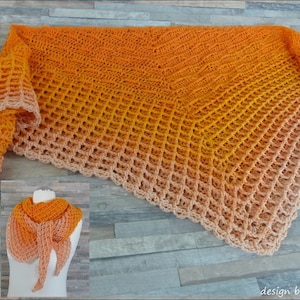 Könnte beinhalten: Ein gehäkeltes Tuch in einem Farbverlauf von Orange, Gelb und Pfirsich. Das Tuch ist mit einem Lochmuster gearbeitet und hat einen Fransenrand. Das Tuch wird auf einer Holzoberfläche gezeigt.