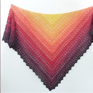 Puede incluir: Un chal triangular de ganchillo con un patrón de color degradado que transiciona de amarillo en el centro a naranja, rojo y morado oscuro en los bordes. El texto Häkelanleitung Crochet Pattern es visible en el lado izquierdo de la imagen.