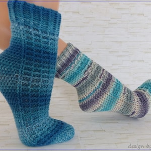 Könnte beinhalten: Ein Paar gehäkelte Socken in einem blauen und violetten Ombre-Muster. Die Socken sind knöchelhoch und haben eine strukturierte Masche.