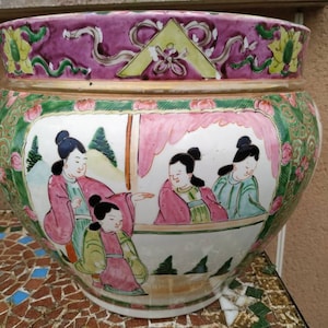 Peut inclure: Grand pot de fleurs chinois antique, rond, avec un large bord. Il présente une scène peinte à la main de personnages en vêtements traditionnels. Le bord est violet foncé avec des motifs floraux et géométriques. Le corps est blanc avec des accents roses, verts et dorés.