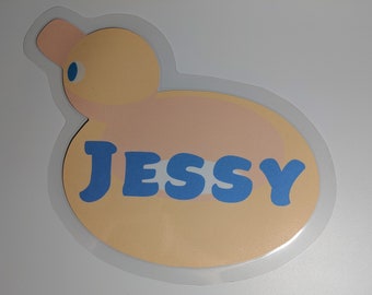 May include: A yellow rubber duck with a blue name tag that says "Jessy".