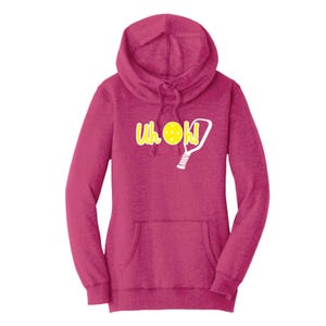 Op de afbeelding: Een magenta hoodie met een kangoeroezak en een capuchon met trekkoord. De voorkant heeft de tekst "Uh OK!" in geel, met een pickleball en paddle graphic. De hoodie is gemaakt van een zacht, comfortabel materiaal.