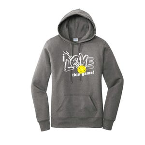 K&ouml;nnte beinhalten: Ein anthrazitfarbener Kapuzenpullover mit einer Vordertasche und wei&szlig;em Text mit der Aufschrift "i LOVE this game!". Ein gelber Pickleball befindet sich in der Mitte des Wortes "LOVE".