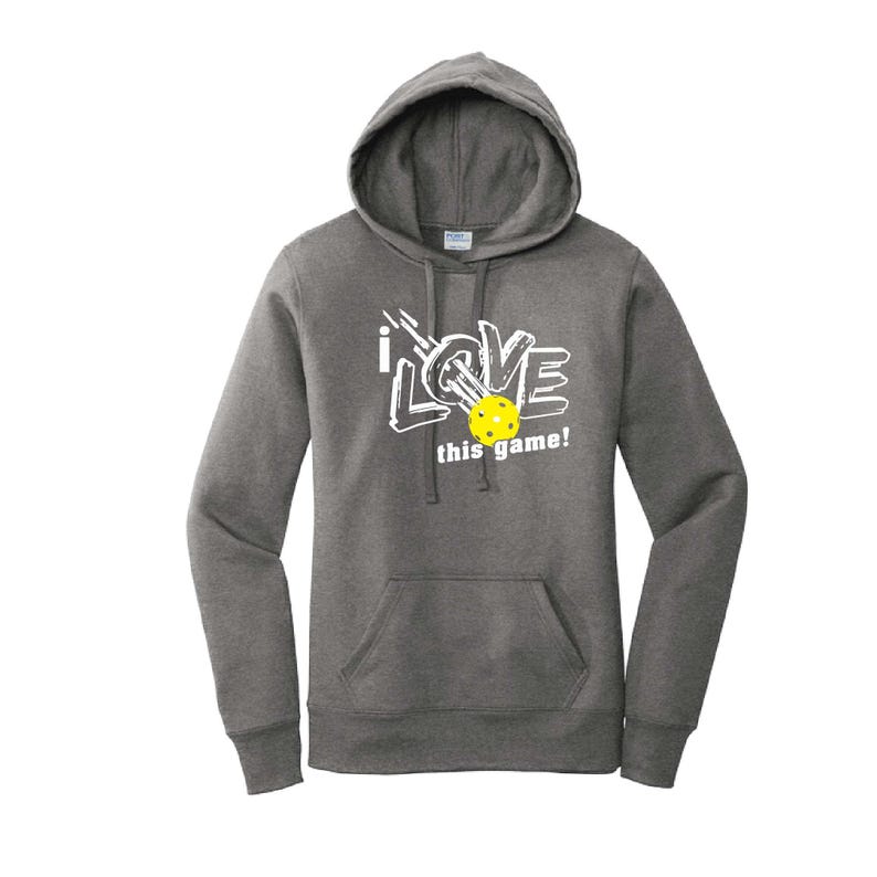 K&ouml;nnte beinhalten: Ein anthrazitfarbener Kapuzenpullover mit einer Vordertasche und wei&szlig;em Text mit der Aufschrift "i LOVE this game!". Ein gelber Pickleball befindet sich in der Mitte des Wortes "LOVE".
