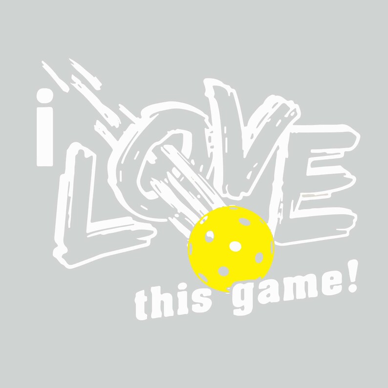 K&ouml;nnte beinhalten: Graue Grafik mit den Worten "I LOVE this game!" in Wei&szlig; und einem gelben Pickleball. Der Text ist im Pinselstrich-Stil gehalten, und der Pickleball hat mehrere L&ouml;cher.