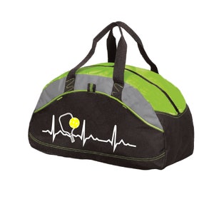 May include: A black, lime green, and grey duffel bag featuring a white heartbeat line graphic that incorporates a pickleball paddle and a yellow pickleball. The bag includes two black fabric handles and a zipped closure along the top section.