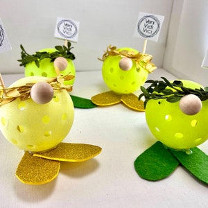 May include: Four yellow and green gnome-like figures with gold glitter accents and a small wooden nose. Each figure has a small sign that reads "veni vidi vici".