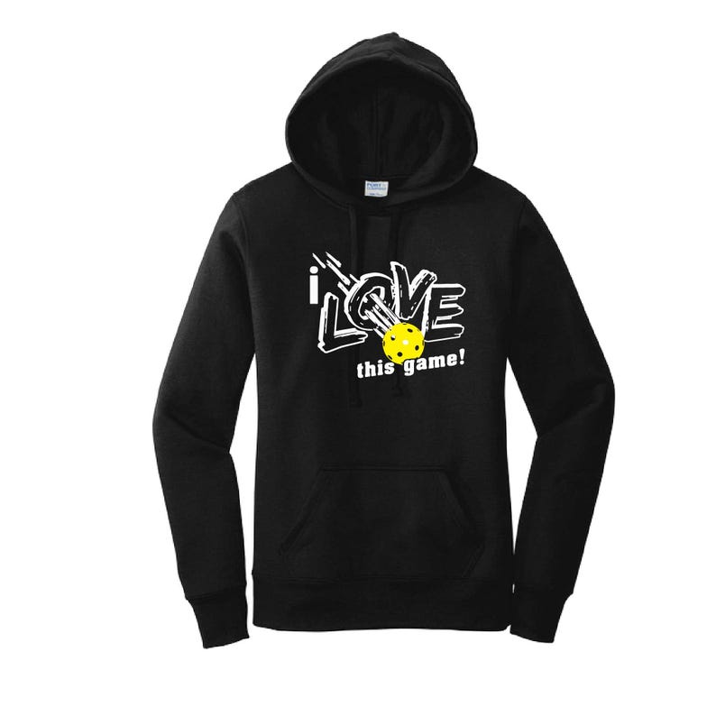 K&ouml;nnte beinhalten: Schwarzer Kapuzenpullover mit wei&szlig;em Aufdruck "I LOVE this game!". In der Mitte des Aufdrucks befindet sich ein gelber Pickleball. Der Pullover hat eine Vordertasche und eine Kapuze mit Kordelzug.