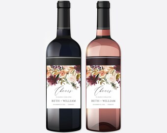 Könnte beinhalten: Zwei Weinflaschen mit personalisierten Etiketten, die ein florales Design in den Farben Burgunder, Pfirsich und Creme zeigen. Die Etiketten tragen den Schriftzug "Cheers" und enthalten die Namen "Beth + William" sowie das Hochzeitsdatum "18. Dezember 2024".