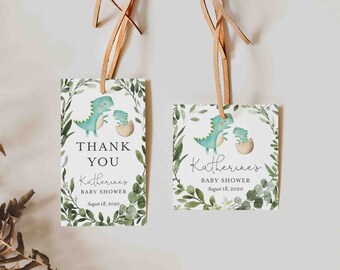 May include: Two green dinosaur baby shower favor tags with a leafy green border. The text on the tags reads "Thank You Katherine's Baby Shower August 18, 2020".