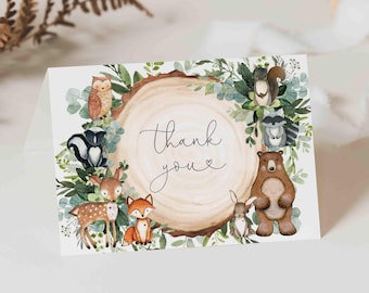 May include: A folded thank you card with illustrations of woodland creatures, including a bear, fox, and owl. The card features a watercolour illustration of a tree trunk and foliage, with the words "Thank you" in cursive.