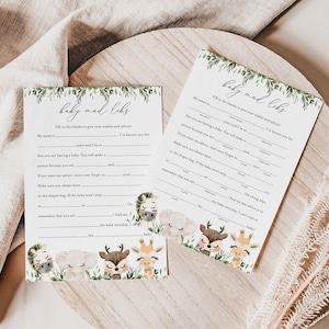 May include: Two printable baby mad libs cards with a woodland theme. The cards feature a cute illustration of animals like a zebra, elephant, deer, and giraffe. The text on the cards reads "Baby Mad Libs" and asks the user to fill in the blanks to give their wishes and advice.