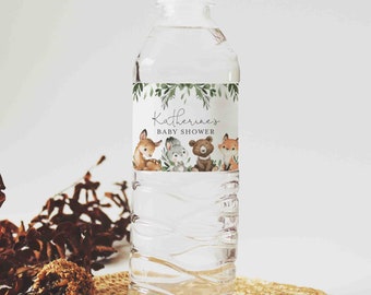May include: Clear plastic water bottle with a white cap. The label features the text "Katherine's BABY SHOWER" with illustrations of a deer, rabbit, bear, and fox. Green foliage borders the top of the label.