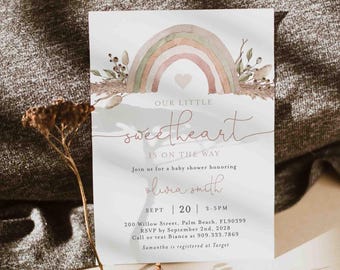 May include: Baby shower invitation featuring a watercolour rainbow design in soft colours. The text reads "Our Little Sweetheart is on the Way" with event details including the date, time, and location. The invitation is decorated with floral elements.