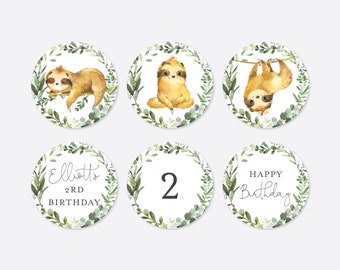 Pode incluir: Seis adesivos redondos para festas com tema de preguiça, de cor branca, verde e marrom. Os adesivos mostram uma preguiça, uma coroa de folhas verdes e o texto "Elliott's 2nd Birthday", "2" e "Happy Birthday".
