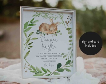 May include: A white sign with a green leafy border and a watercolor illustration of a fawn. The sign reads "Diaper Raffle" and includes instructions for guests to leave their raffle tickets if they brought diapers. The text "sign and card included" is written in black on a white circle in the upper right corner.