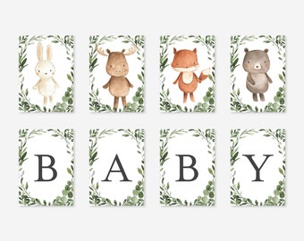 May include: A printable baby shower banner with a woodland theme. The banner features a white rabbit, a brown moose, a red fox, a brown bear, and the letters B, A, B, Y. The letters and animals are surrounded by green leaves.