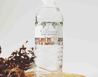 May include: A clear plastic water bottle with a white label that says "Katherine's Baby Shower" with a green leafy border and a row of woodland animals including a bear, fox, moose, rabbit, and raccoon.