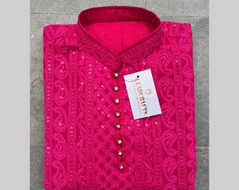 Puede incluir: Una kurta rosa de manga larga con cuello alto y bordados intrincados. La kurta está adornada con lentejuelas y tiene un cierre de botón en el cuello. La tela es transparente y ligera. La etiqueta en la kurta dice "LEADCRAFTS".