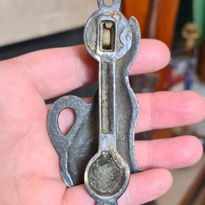 May include: Antique brass door knocker shaped like a dog. The knocker has a detailed design and a round, flat base.