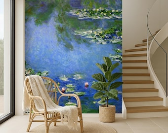 May include: A large wall mural featuring an impressionist painting of a water lily pond with blue, green, and purple tones. In front of the mural sits a light-colored rattan armchair draped with a cream-colored throw blanket and a green potted plant.