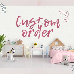 Könnte beinhalten: Ein Kinderzimmer mit einer weißen Wand, auf der der Text Custom Order in rosa Pinselstrichschrift steht, einer Holzkommode, einem kleinen Tisch mit zwei Stühlen, einem hausförmigen Bettgestell mit rosa Bettwäsche, einem Schaukelpferd und Plüschtieren.
