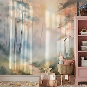 May include: A watercolor forest mural in soft pastel colors, with a path leading through the trees. A pink cabinet with shelves holds toys and decorative items. A wicker chair and stacked suitcases add to the whimsical scene.