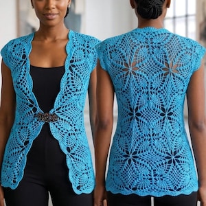 Op de afbeelding: Een fel turquoise gehaakt vest met een ingewikkeld, op bloemen geïnspireerd opengewerkt patroon, korte mouwen en een geschulpte rand. De voorzijde is in de taille vastgezet met een donkere, veelzijdige decoratieve broche.