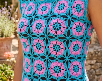 Pode incluir: Um top de crochê sem mangas com um padrão repetitivo de motivos cor-de-rosa em forma de flor conectados por fio turquesa brilhante. A peça tem um decote redondo e uma borda festonada, usada sobre uma camada base preta para destacar o design.