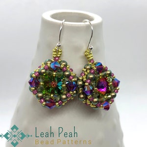 Puede incluir: Un par de pendientes de aro de plata con un racimo cuadrado de cuentas iridiscentes de color verde, rosa y dorado.