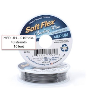 Op de afbeelding: Twee spoelen Soft Flex kralendraad. De bovenste spoel heeft een wit en blauw etiket met de tekst "Soft Flex Beading Wire". Het etiket geeft aan dat de draad medium is, 0,48 mm diameter, 49 strengen en 3,05 m lang.
